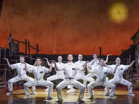 Production shot of The Book of Mormon in London featuring the 'Mormons' ensemble.