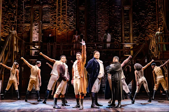 Production shot of Hamilton in London, with Shan Ako as Eliza Hamilton, Allyson Ava Brown as Angelica Schuyler and Roshani Abbey as Peggy Schuyler.